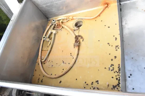 Commercial 3 bay sink, stainless steel, used condition with visible rust and debris, includes plumbing fixtures.
