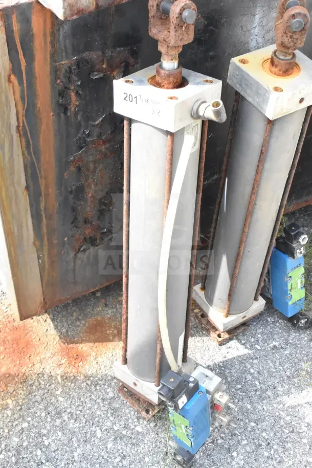Two Miller W AL84B2B pneumatic cylinders, visible rust, with attached components. Marked "201," sold as pair.