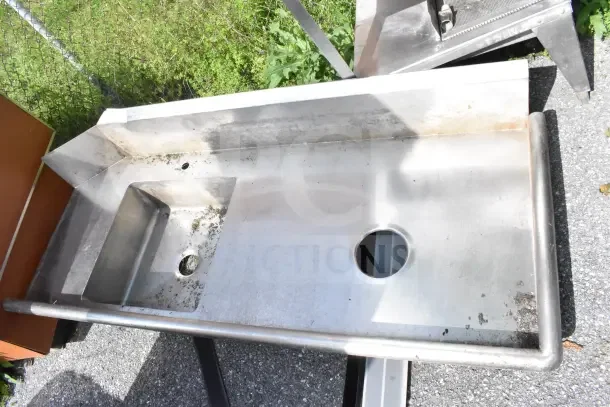 Commercial right side dirty side dishwasher table without legs, stainless steel, visible wear, drainage holes.