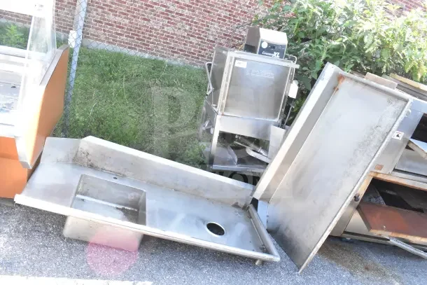 Jackson Conserver XL commercial dishwasher with stainless steel tables, showing visible wear. Model markings visible.