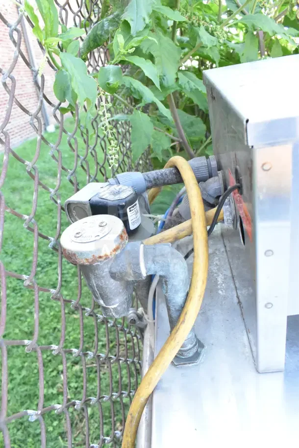 Jackson Conserver XL commercial dishwasher with visible electrical and water connections, outdoor setting.