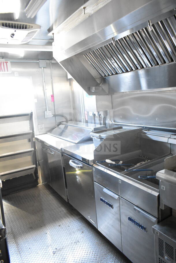 2021 Rock Solid Cargo 8.5'x24' food trailer interior, featuring stainless steel equipment, exhaust hood, and slip-resistant flooring.