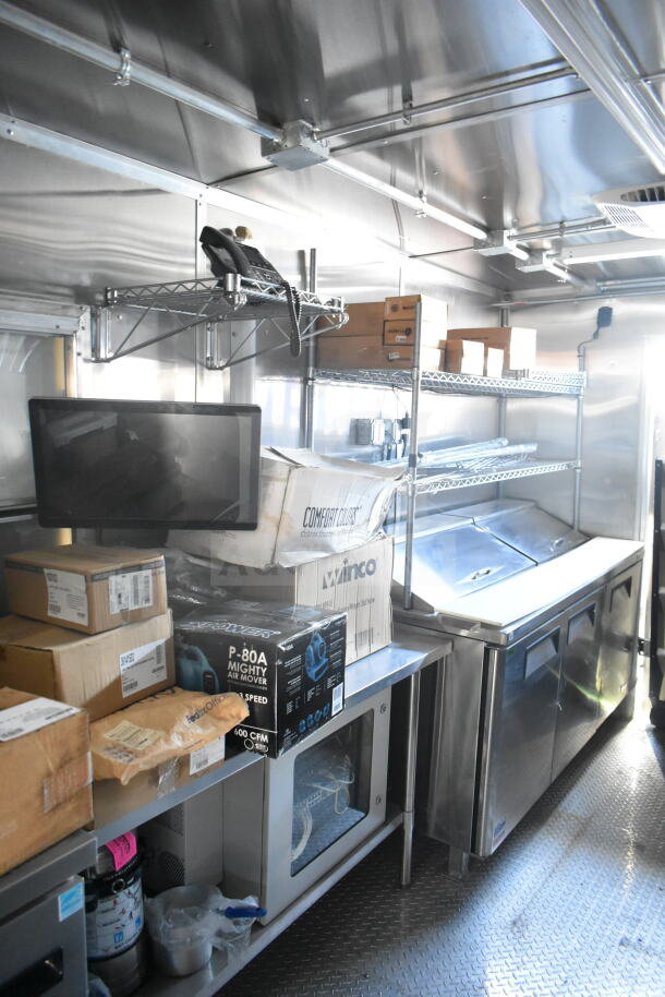 2021 Rock Solid Cargo 8.5'x24' food trailer interior, stainless steel surfaces, storage shelving, commercial kitchen setup.