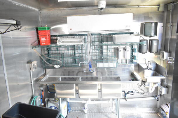 Interior of 2021 Rock Solid Cargo 8.5'x24' food trailer with stainless steel sinks, shelving, VentusX unit, and plumbing fixtures.