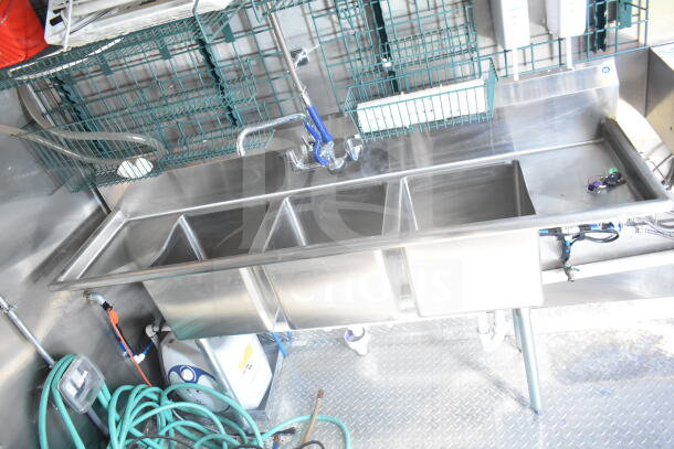 "2021 Rock Solid Cargo 8.5'x24' food trailer interior showing stainless steel triple sink, hose, and shelves in clean condition."