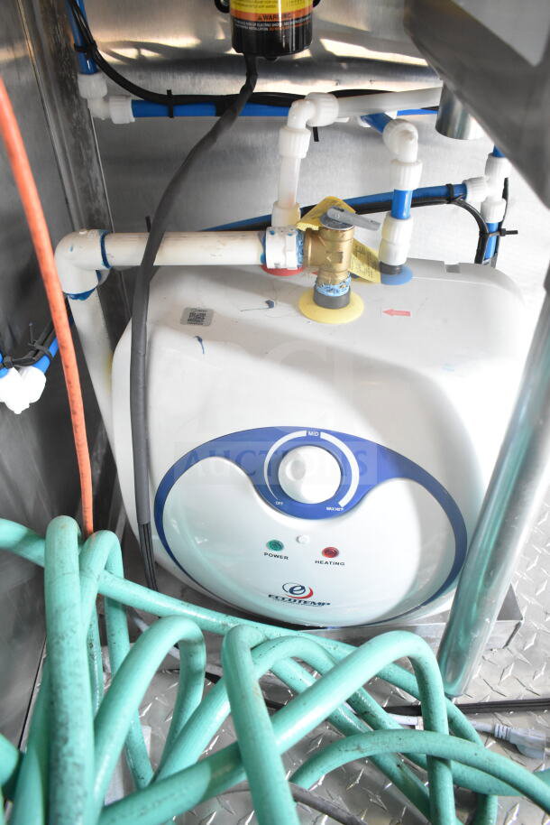 Inside view of 2021 Rock Solid Cargo food trailer showing EcoTemp water heating system with connected pipes and hoses.