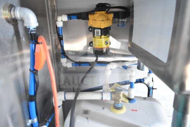 Interior view of a 2021 Rock Solid Cargo 8.5'x24' food trailer, showing a Flow-Max water filtration system with blue piping setup.