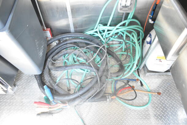 Cables and hoses inside a 2021 Rock Solid Cargo 8.5'x24' food trailer. Visible wiring for electrical setup.