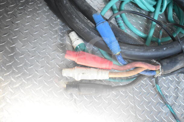 Colored industrial cables on diamond-plate metal flooring in Rock Solid Cargo food trailer, VIN 7H2BE2426MD037994.