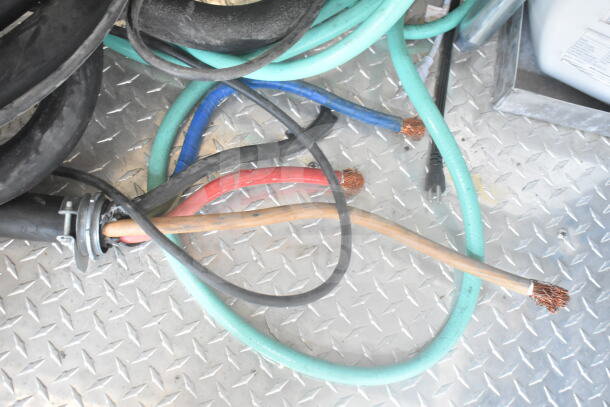Loose cables on diamond plate flooring of 2021 Rock Solid Cargo food trailer, showing internal wiring condition.