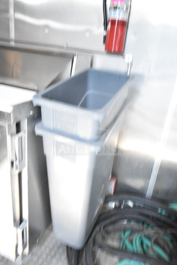 Interior of a 2021 Rock Solid Cargo food trailer featuring a CaptiveAire grease hood, fire extinguisher, and storage bin.