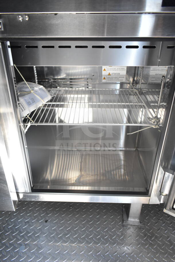 Stainless steel refrigeration unit in 2021 Rock Solid Cargo food trailer, open with wire shelving visible, includes safety warnings.