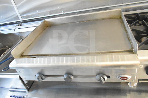 Rock Solid Cargo food trailer interior featuring Wells grill, Imperial gas fryer, and stainless-steel surfaces.