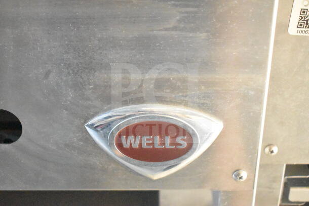 Close-up of a Wells logo on stainless steel, indicating the inclusion of Wells equipment in the 2021 Rock Solid Cargo food trailer.