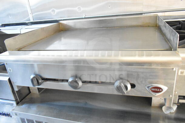 2021 Rock Solid Cargo 8.5'x24' food trailer interior showing Wells griddle, control knobs, and stainless steel finish.