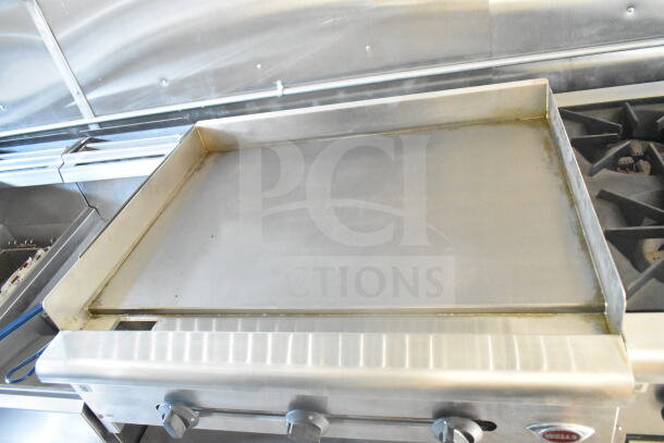 2021 Rock Solid Cargo food trailer interior showing stainless steel griddle, part of a full kitchen suite with grease hood.