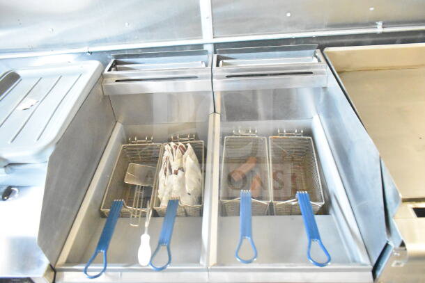 Interior of 2021 Rock Solid Cargo 8.5'x24' food trailer featuring Imperial gas fryers with blue handles and cooking items inside.