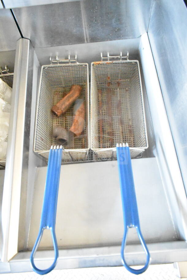 Imperial gas fryer with stainless steel baskets, featuring blue handles; part of 2021 Rock Solid Cargo food trailer setup.