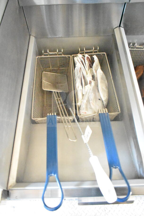 Imperial gas fryers with blue handles, featuring two wire baskets, inside a 2021 Rock Solid Cargo food trailer.