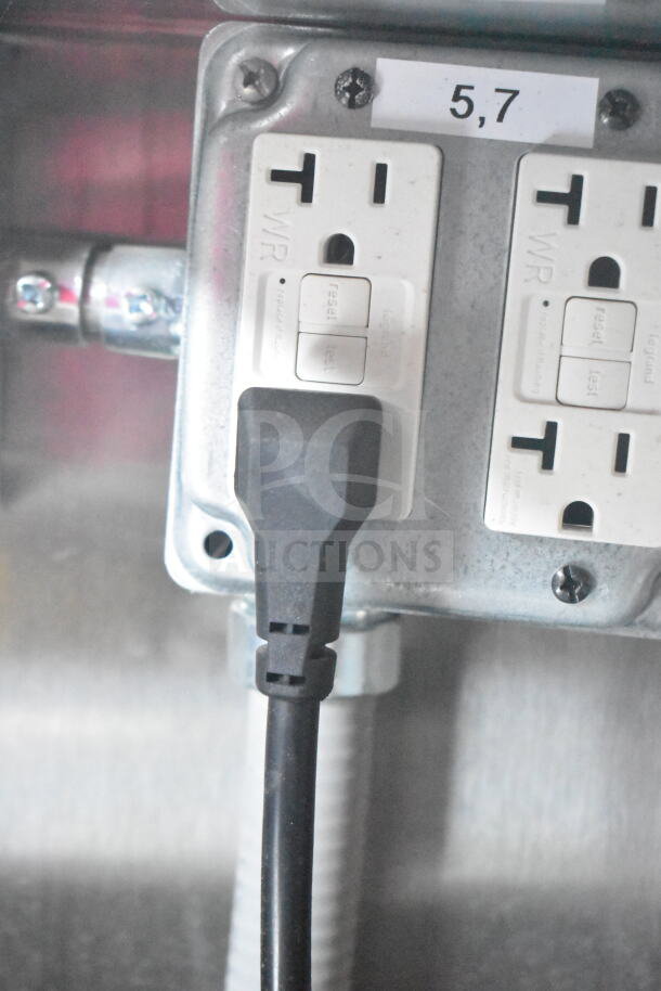 Close-up of an electrical outlet with a plugged-in cord inside a 2021 Rock Solid Cargo food trailer.