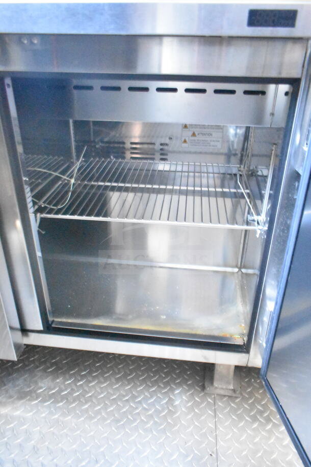 Interior of 2021 Rock Solid Cargo 8.5'x24' food trailer showing stainless steel refrigeration suite with shelving.