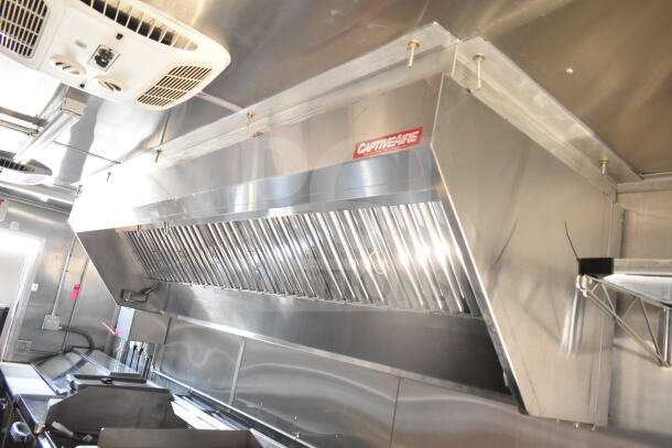 2021 Rock Solid Cargo 8.5'x24' food trailer interior with CaptiveAire grease hood, showcasing stainless steel construction.