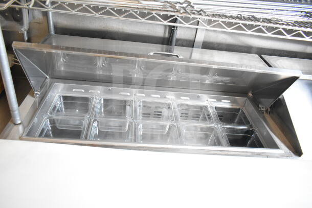 Interior of 2021 Rock Solid Cargo food trailer, showcasing a stainless steel refrigeration suite with multiple compartments.