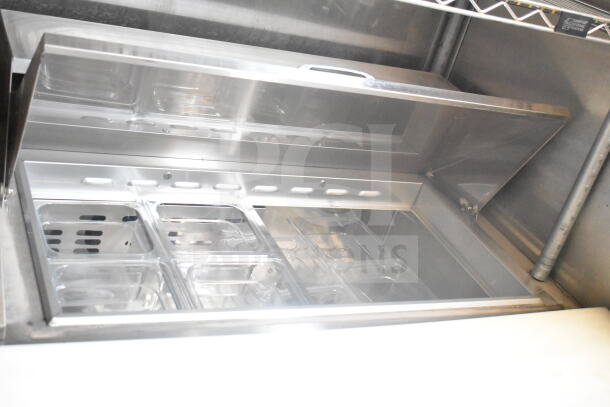 Interior view of a 2021 Rock Solid Cargo 8.5'x24' food trailer. Stainless steel storage with compartments; CaptiveAire hood visible.