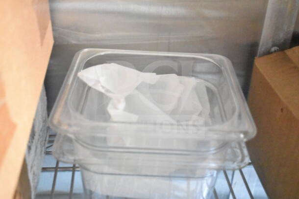 A clear plastic container filled with paper, placed on a metal shelf, surrounded by cardboard boxes.