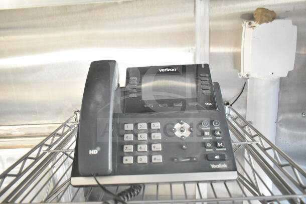 Yealink T46S phone on metal rack, labeled "Verizon HD." Suitable for office or industrial use.