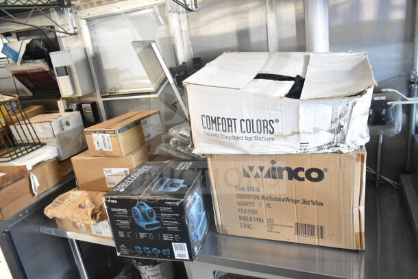 Interior of a 2021 Rock Solid Cargo food trailer with boxes labeled Comfort Colors and Winco. Features durable surfaces.