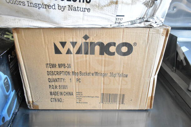 Cardboard box labeled "Winco" containing a 0.36 qt yellow mop bucket with wringer, item #MPB-36, made in China.