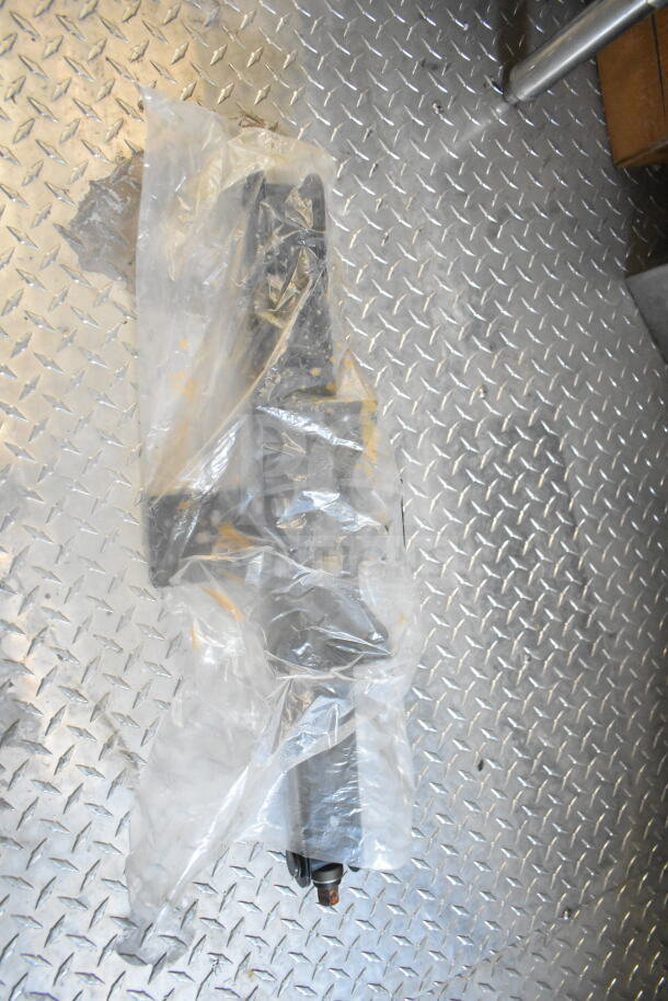 Plastic-wrapped component on a metal diamond plate floor inside a 2021 Rock Solid Cargo 8.5'x24' food trailer.