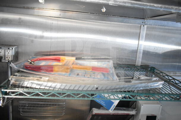 Interior of 2021 Rock Solid Cargo food trailer showcasing metal shelving with tools, wiring, and equipment for maintenance.
