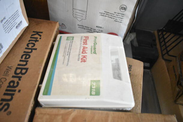 ProGuard First Aid Kit on kitchen supplies, including Kitchen Brains packaging, indicating emergency preparedness.