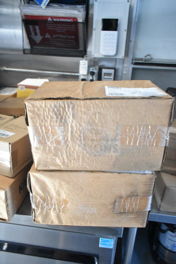 Stacked cardboard boxes inside a 2021 Rock Solid Cargo food trailer with a CaptiveAire hood, visible in a storage area.