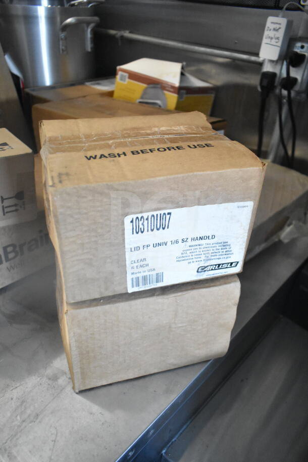 An open box labeled "Carlisle LID FP UNIV 1/6 SZ HANDLD, Clear, 6 Each, Made in USA" with warning text. Marked "10310U07."