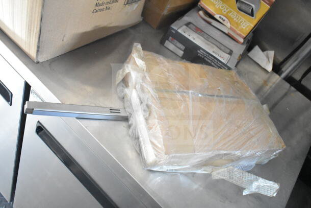 A wrapped package with metal rod on a stainless steel surface, next to a cardboard box labeled "Made in China."