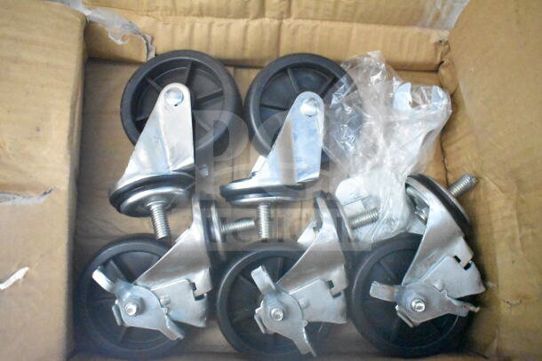 Box of metal and plastic swivel casters with brakes, partially wrapped in plastic, in cardboard packaging.