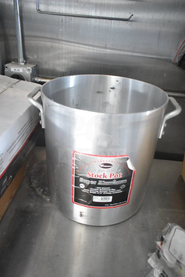 Aluminum stock pot labeled "Stock Pot" with reinforced rim, premium collection, on metal surface.