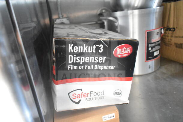 Box of TableCraft Kenkut 3 Dispensers for film or foil, shown on stainless steel counter in food trailer kitchen.