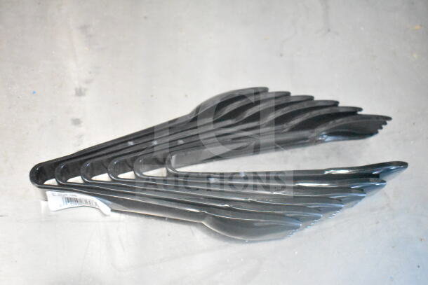 A set of black plastic spoons stacked together on a light gray surface. A white label with barcode is attached.