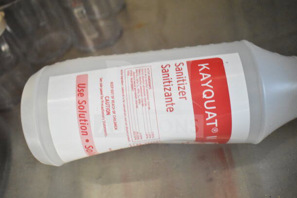 A clear bottle of Kayquat sanitizer with red label showing usage instructions.