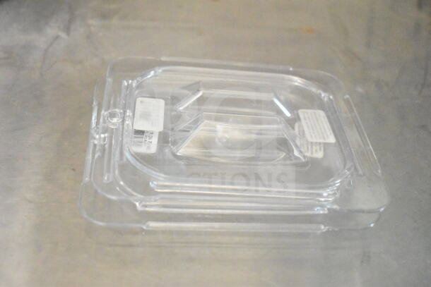 Clear plastic tray lid with handles, placed on a metallic surface. Labels with text visible on the top surface.