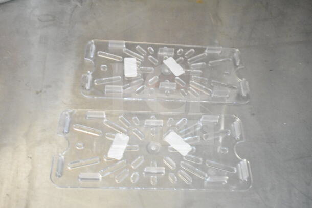 Clear plastic ventilation panels on a metal surface, featuring geometric cutouts and paper labels.