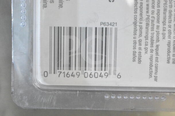 Close-up image of a product barcode with serial number 071649060496. Includes safety warnings in multiple languages.