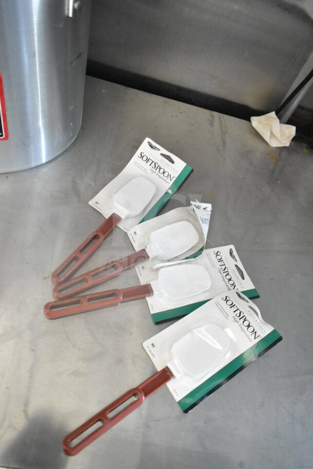 Four Vollrath SoftSpoon high-temperature spatulas on a metallic surface. Spatulas are in original packaging.