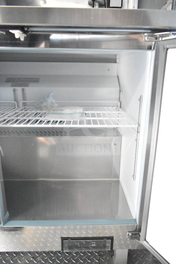 Interior view of the 2021 Rock Solid Cargo 8.5'x24' food trailer's refrigeration suite, showing clean, spacious shelves.