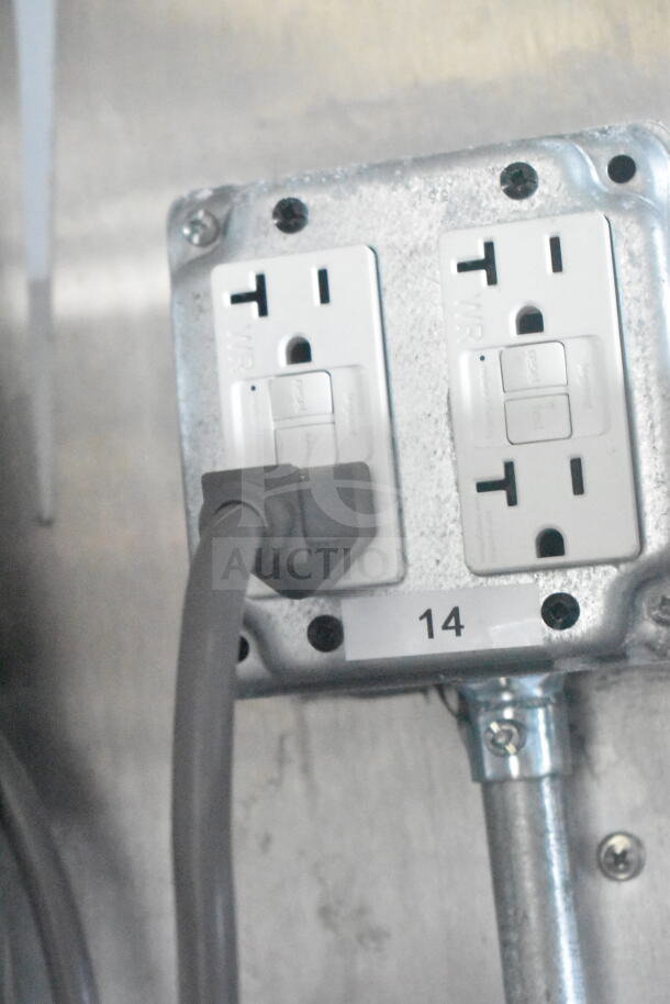 Electrical outlet labeled "14" with a plugged-in cord inside a 2021 Rock Solid Cargo 8.5'x24' food trailer.