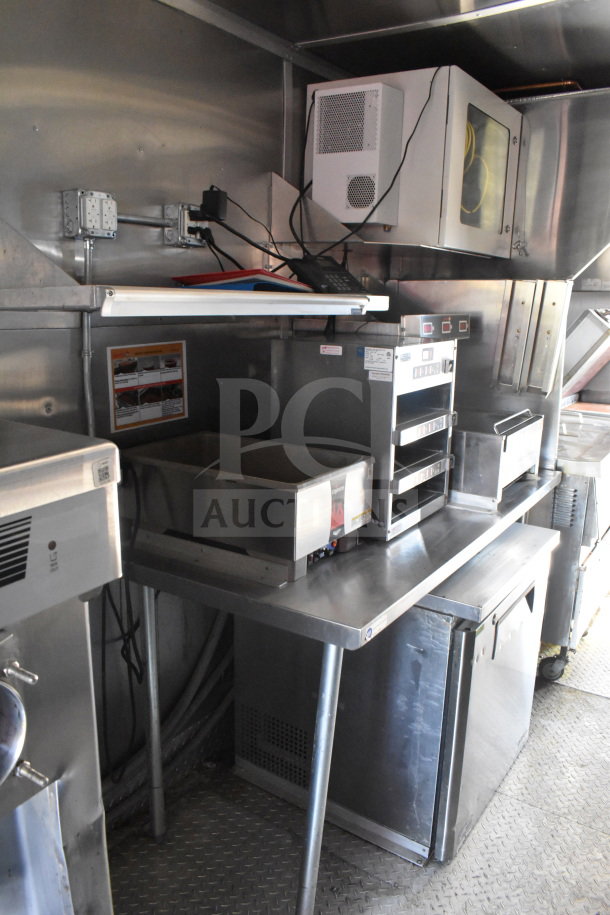 2021 Rock Solid Cargo 8.5'x28' food trailer interior with stainless steel counters, appliances, and wiring, in good condition.